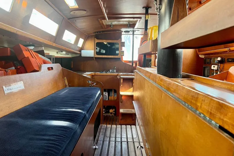 Slide: The Image of Interior of a 1982 Santa Cruz 50 sailboat, featuring wooden furnishings and cozy seating. - 14
