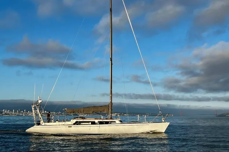 Slide: The Image of 1982 Santa Cruz 50 sailboat cruising on calm waters under a clear blue sky. - 2