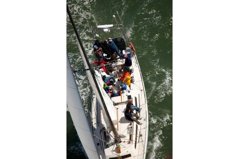 Slide: The Image of Aerial view of 1982 Santa Cruz 50 sailboat with crew navigating through water. - 3