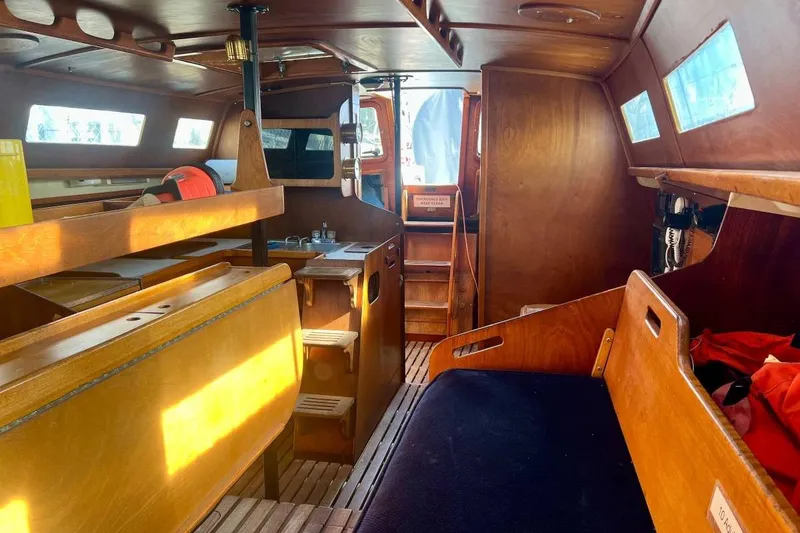 Slide: The Image of Interior of a 1982 Santa Cruz 50 sailboat with wooden furnishings and seating. - 8
