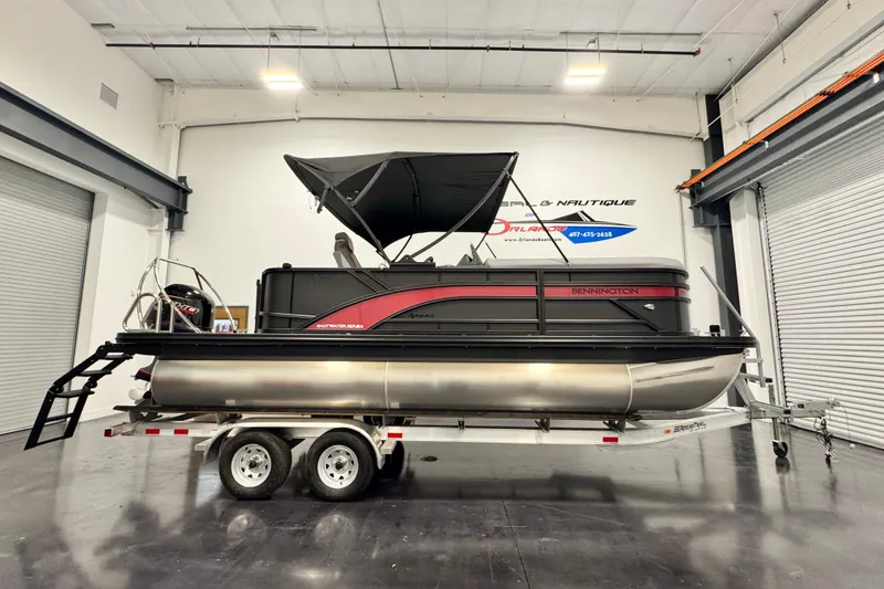 The Image of 2026 Bennington 20S Cruise pontoon boat on trailer in indoor showroom. - 0