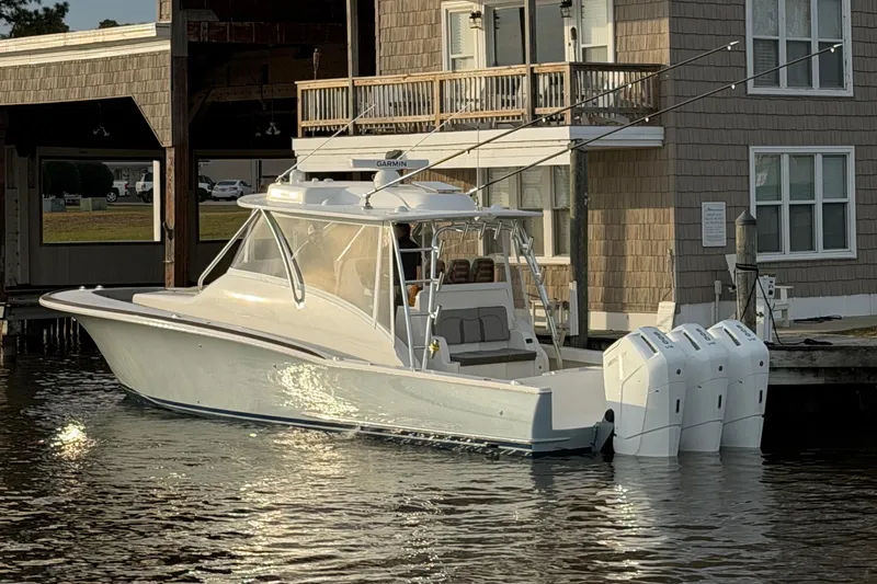 Slide: The Image of 2026 Albemarle 45 Carolinian Fisharound Express boat docked by a waterfront building. - 2