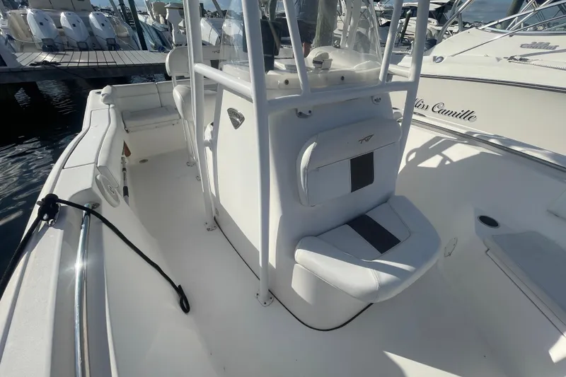 Slide: The Image of 2013 Tidewater 210 LXF boat interior with seating and console, docked at marina. - 12