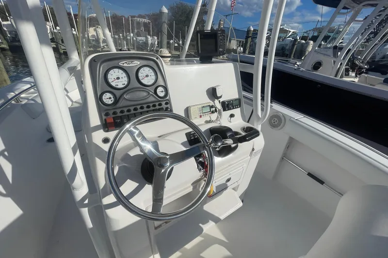 Slide: The Image of 2013 Tidewater 210 LXF boat dashboard with steering wheel and gauges at marina. - 14