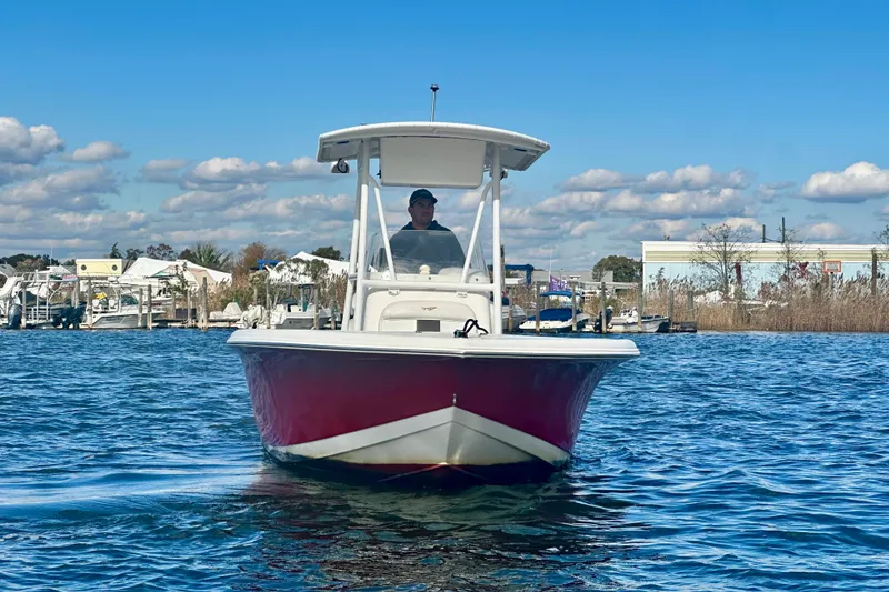 Slide: The Image of 2013 Tidewater 210 LXF boat on water, clear sky, marina background. - 4