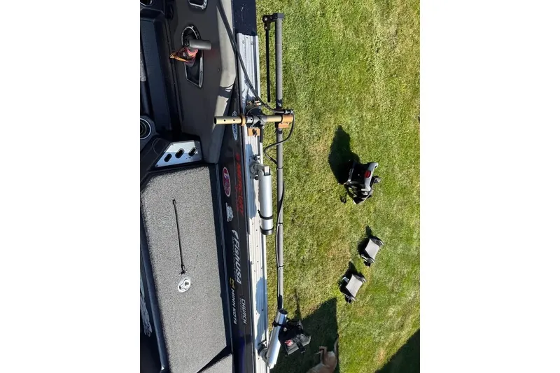 Slide: The Image of 2022 Ranger 622FS Pro Touring boat on grass, fishing gear visible. - 4