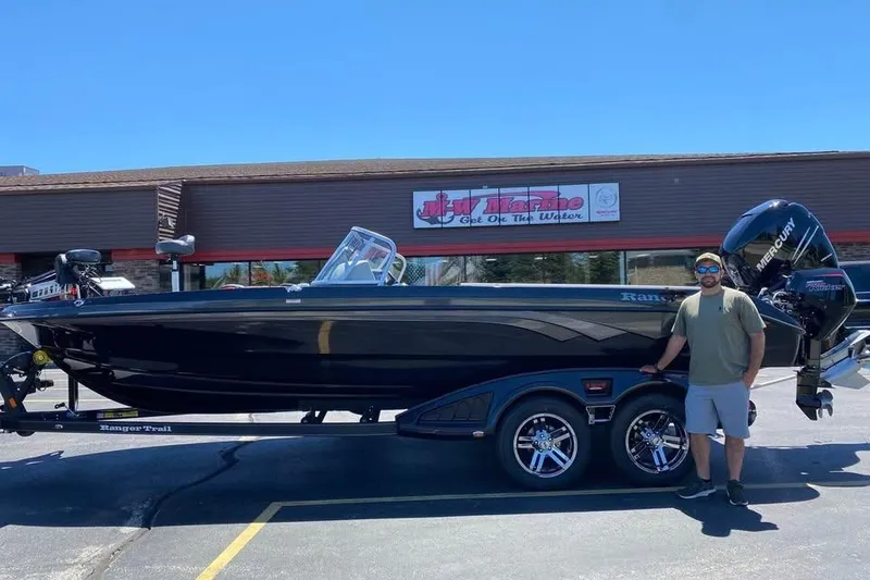 Slide: The Image of 2022 Ranger 622FS Pro Touring boat with Mercury engine, parked outside a marine store. - 8