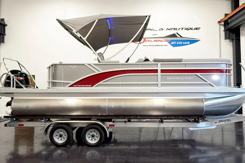 The Image of 2025 Bennington 21S Cruise pontoon boat with canopy on trailer in showroom. - 1