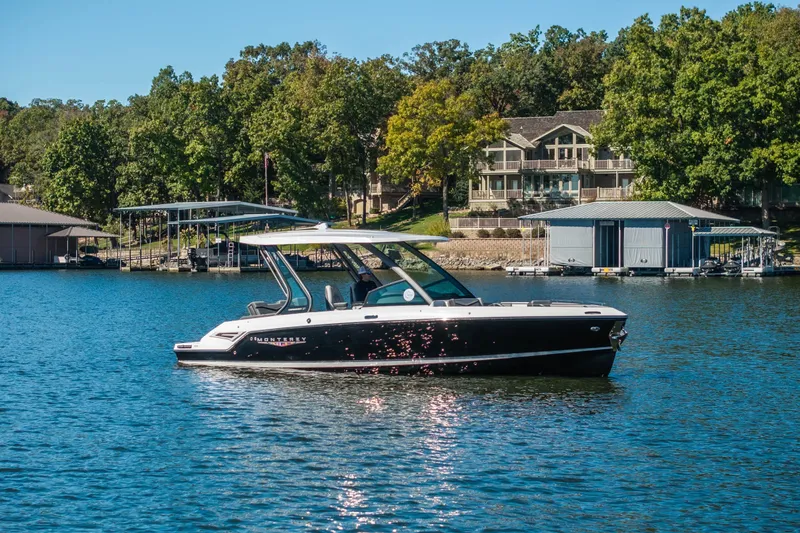 The Image of 2026 Monterey Elite 27 SD boat on a serene lake with lush greenery. - 1
