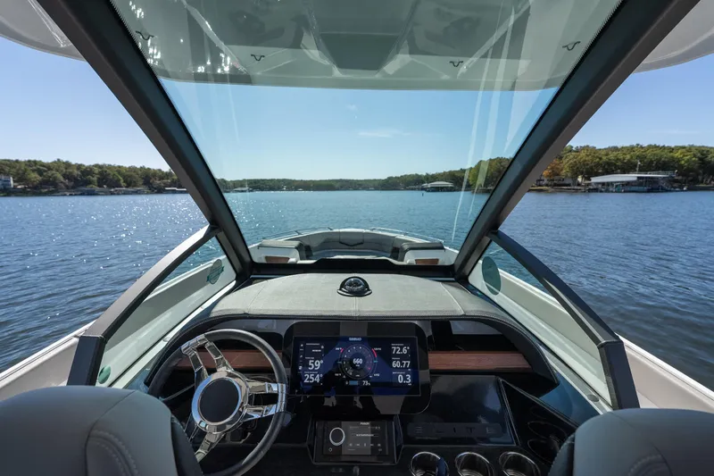 Slide: The Image of Cockpit view of 2026 Monterey Elite 27 SD boat on a serene lake. - 10