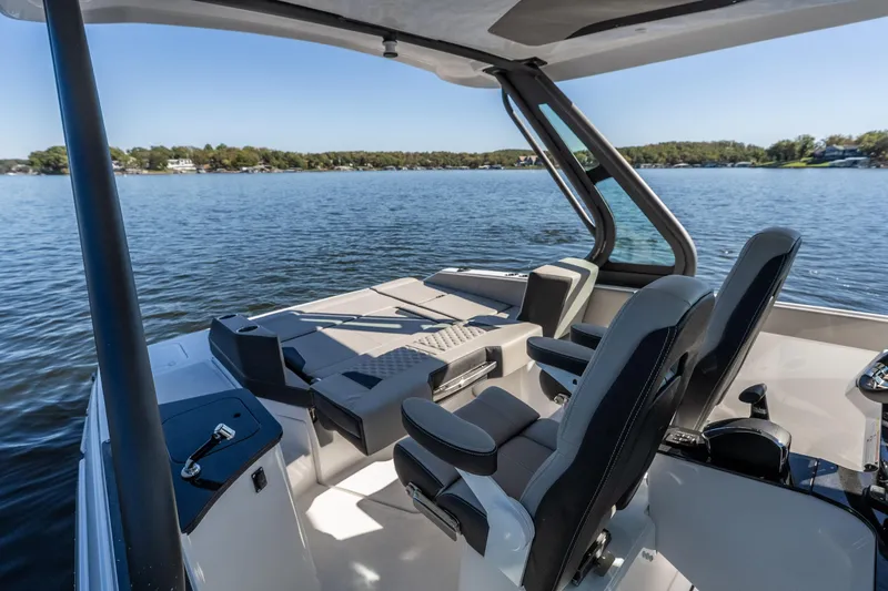 Slide: The Image of 2026 Monterey Elite 27 SD boat interior with seating, overlooking a serene lake. - 27