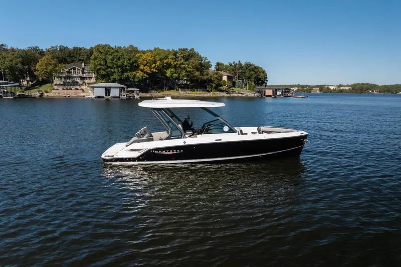 Slide: The Image of 2026 Monterey Elite 27 SD boat cruising on a serene lake under a clear blue sky. - 35