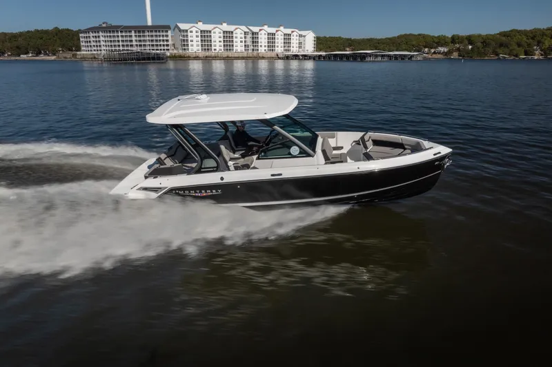 Slide: The Image of 2026 Monterey Elite 27 SD boat cruising on a lake near waterfront buildings. - 5