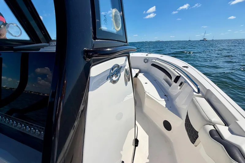 Slide: The Image of 2023 Tidewater 232 LXF boat on open water, showcasing sleek design and spacious seating. - 16