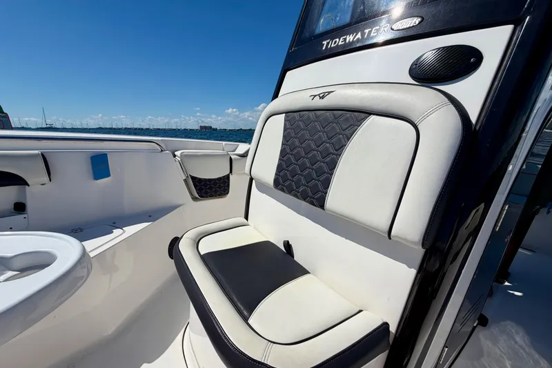 Slide: The Image of 2023 Tidewater 232 LXF boat interior with cushioned seating and ocean view. - 18