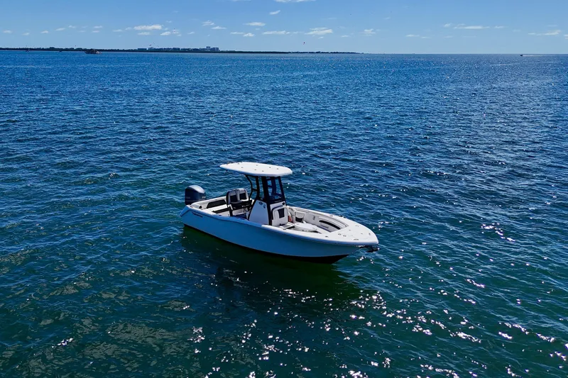 Slide: The Image of 2023 Tidewater 232 LXF boat on open blue water under clear sky. - 2