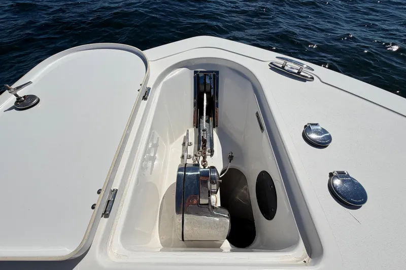 Slide: The Image of 2023 Tidewater 232 LXF boat anchor compartment with open hatch on the water. - 25