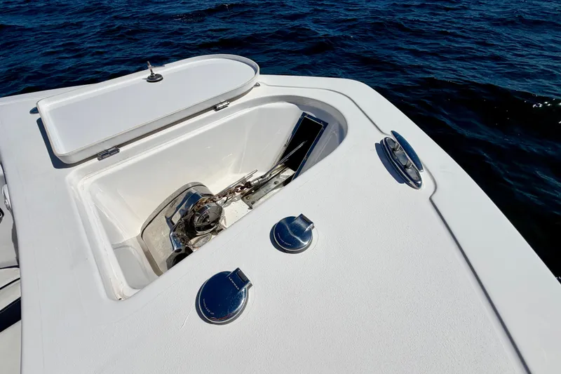 Slide: The Image of 2023 Tidewater 232 LXF boat anchor compartment with open hatch on calm water. - 26