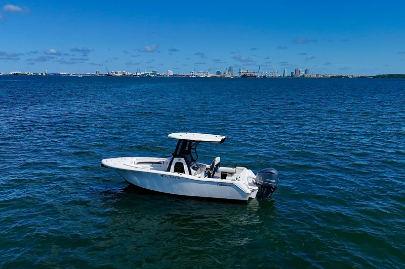 Slide: The Image of 2023 Tidewater 232 LXF boat on open water with city skyline in background. - 5