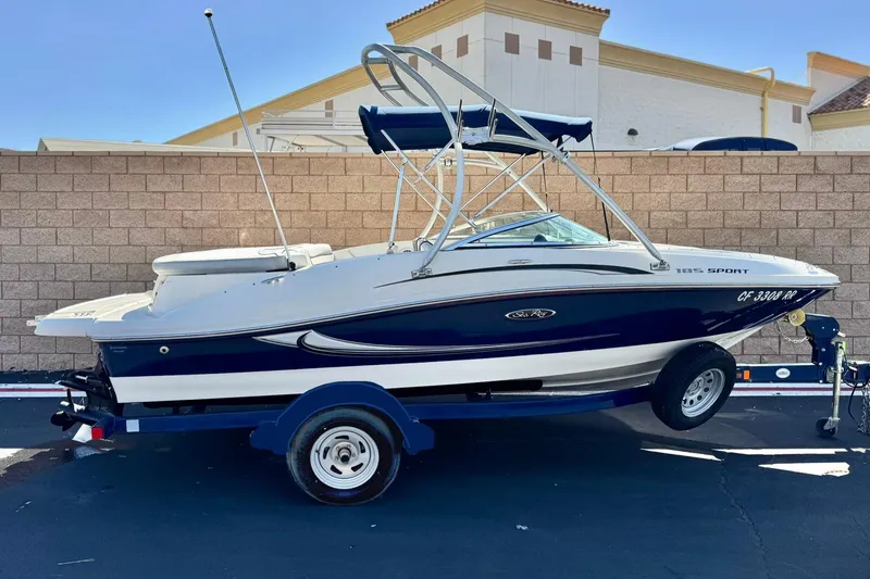 The Image of 2009 Sea Ray 185 Bow Rider boat on trailer, parked outdoors. - 0