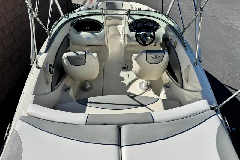 Slide: The Image of 2006 Bayliner 215 Bowrider interior with seating and steering wheel, showcasing boat design. - 10