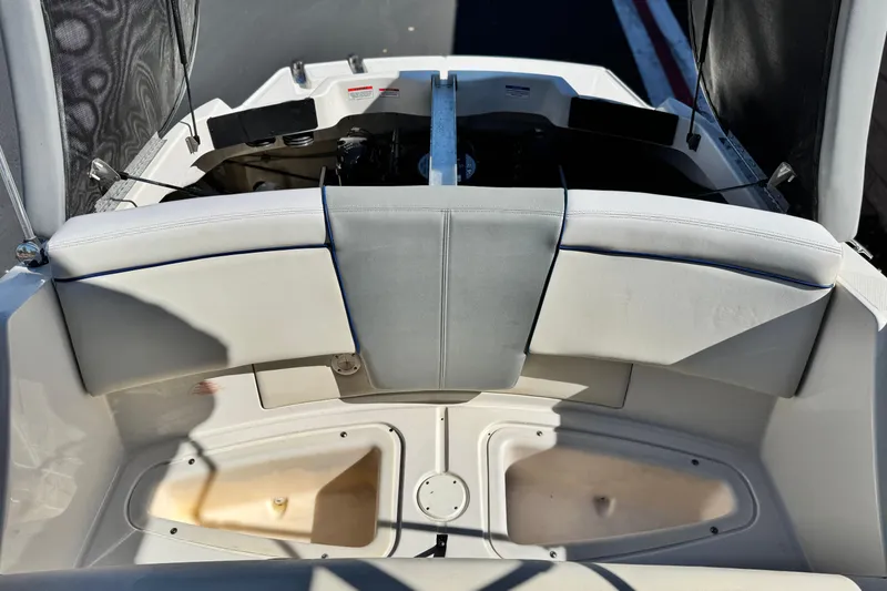 Slide: The Image of 2006 Bayliner 215 Bowrider interior with cushioned seating and storage compartments. - 17