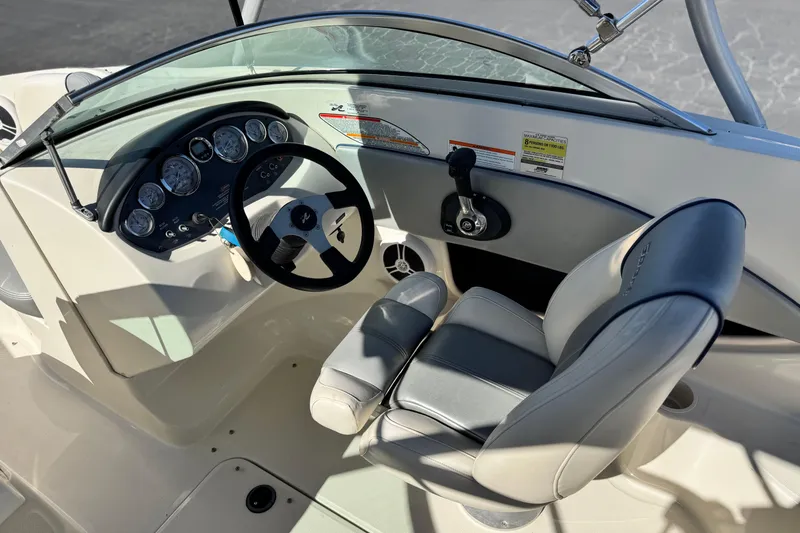 Slide: The Image of 2006 Bayliner 215 Bowrider cockpit with steering wheel and gauges, featuring comfortable seating. - 23