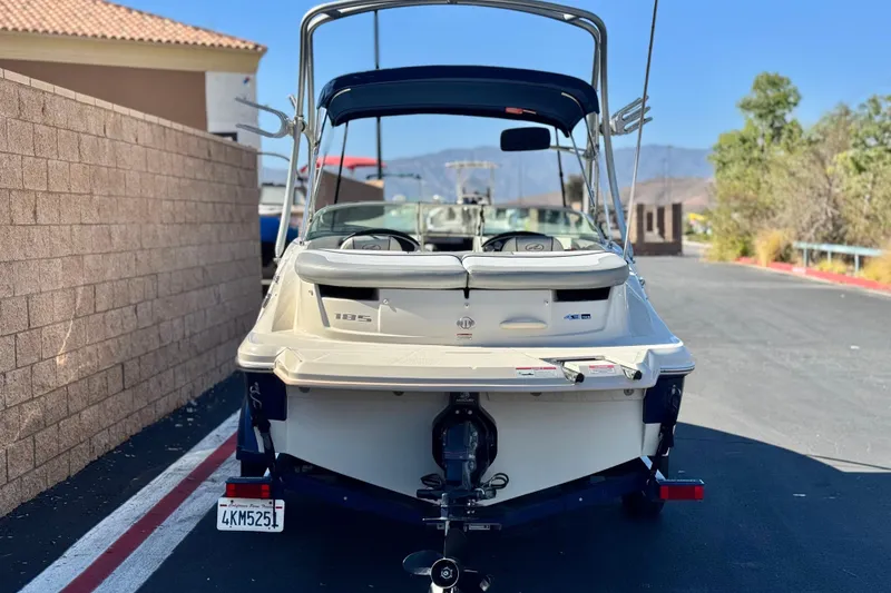 Slide: The Image of 2006 Bayliner 215 Bowrider boat parked on a sunny street. - 4