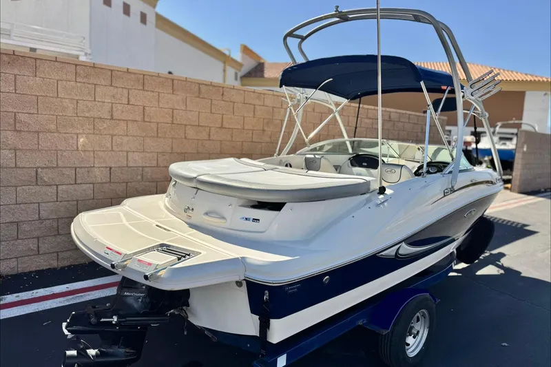 Slide: The Image of 2006 Bayliner 215 Bowrider boat on trailer, parked outdoors, featuring a sleek design. - 5