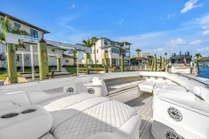 Slide: The Image of Luxurious 2023 HCB 53 Suenos RXV boat docked at a marina with modern waterfront homes. - 103