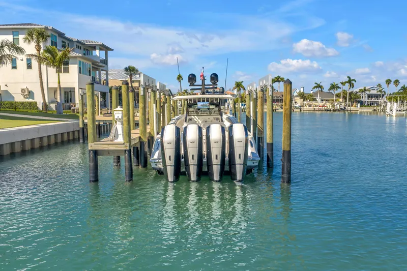 Slide: The Image of 2023 HCB 53 Suenos RXV docked in a scenic marina with palm trees. - 12