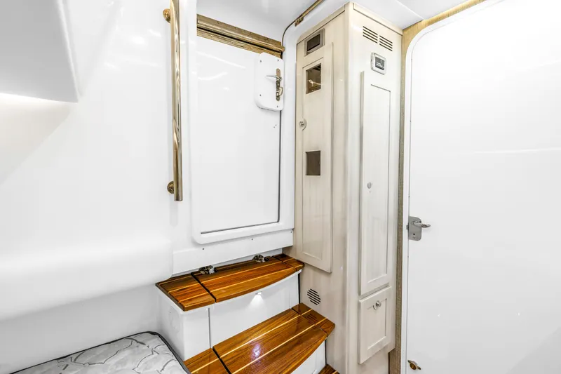 Slide: The Image of 2023 HCB 53 Suenos RXV interior with wooden steps and white cabinetry. - 124