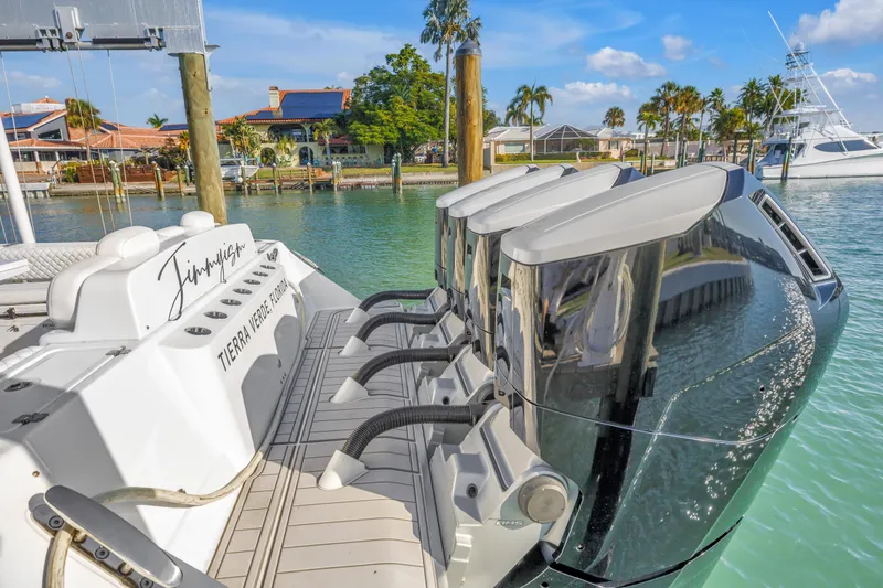 Slide: The Image of 2023 HCB 53 Suenos RXV boat with powerful outboard engines docked in sunny marina. - 128