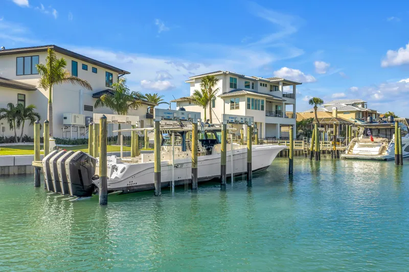 Slide: The Image of 2023 HCB 53 Suenos RXV boat docked in a scenic waterfront marina. - 13