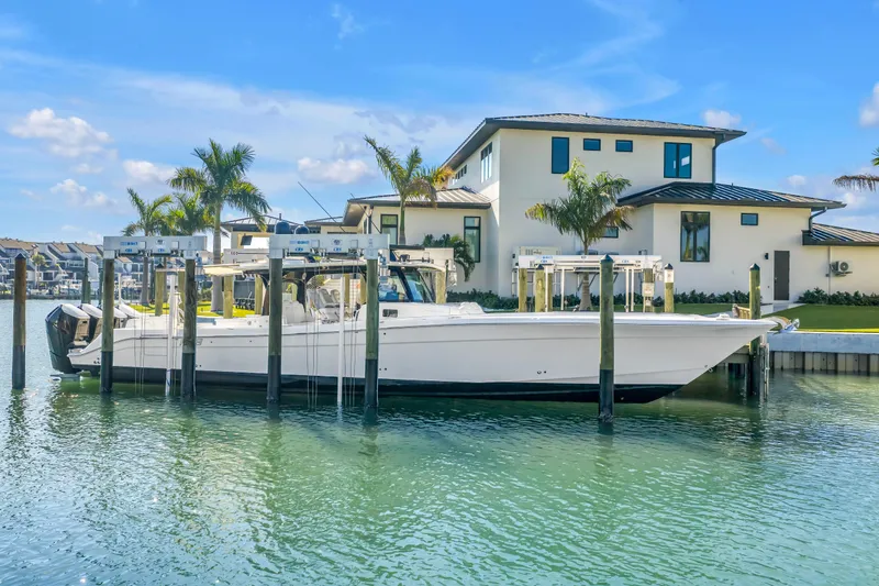 Slide: The Image of 2023 HCB 53 Suenos RXV boat docked by a modern waterfront home. - 15