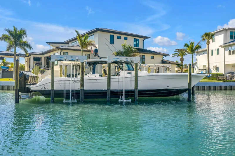 Slide: The Image of 2023 HCB 53 Suenos RXV boat docked near luxury waterfront homes. - 20