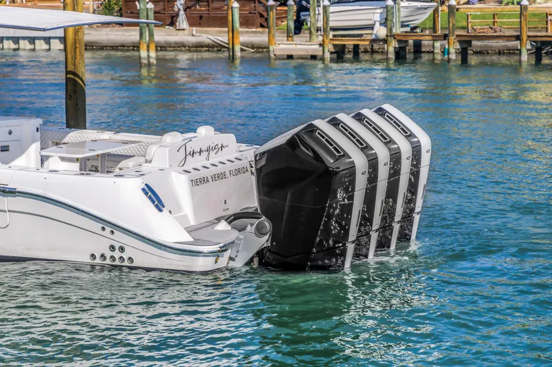 Slide: The Image of 2023 HCB 53 Suenos RXV boat with four powerful outboard engines docked in clear water. - 25