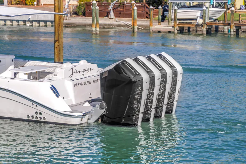 Slide: The Image of 2023 HCB 53 Suenos RXV boat with four powerful outboard engines docked in clear water. - 27
