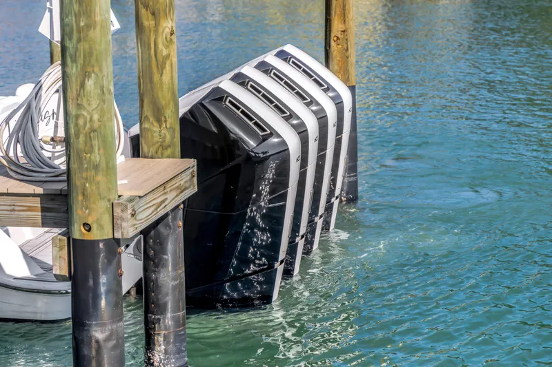 Slide: The Image of Four powerful outboard motors on a 2023 HCB 53 Suenos RXV docked in clear water. - 30