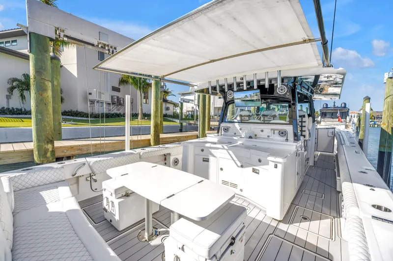 Slide: The Image of 2023 HCB 53 Suenos RXV luxury boat interior with seating and table, docked at marina. - 48