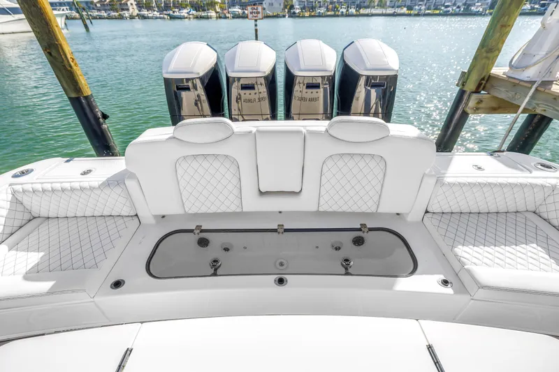 Slide: The Image of 2023 HCB 53 Suenos RXV boat with luxurious seating and powerful engines docked by the water. - 52