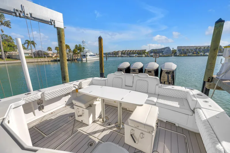 Slide: The Image of 2023 HCB 53 Suenos RXV luxury boat interior with seating and table, docked by waterfront. - 75