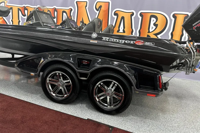 Slide: The Image of 2022 Ranger Z521L boat on display with sleek black design and dual axle trailer. - 50