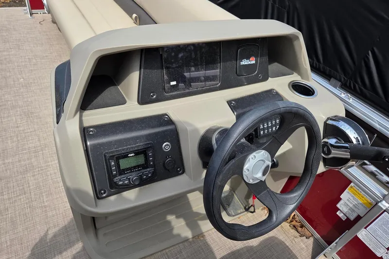 Slide: The Image of 2026 Sun Tracker Party Barge 18 DLX dashboard with steering wheel and controls. - 11