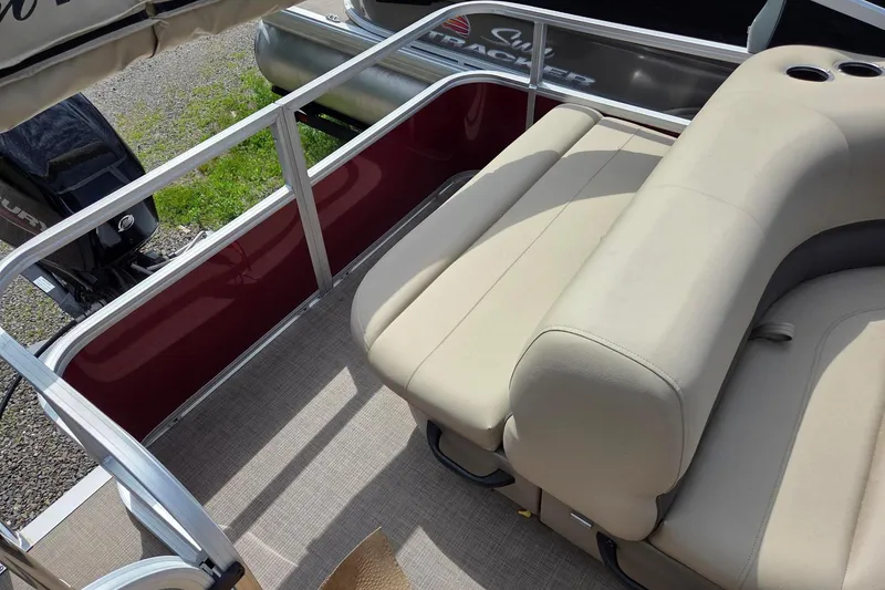 Slide: The Image of 2026 Sun Tracker Party Barge 18 DLX with beige seating and red side panel. - 8
