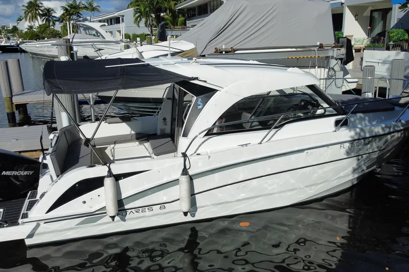 Slide: The Image of 2022 Beneteau Antares 8 boat docked in a marina, featuring sleek design and canopy. - 13