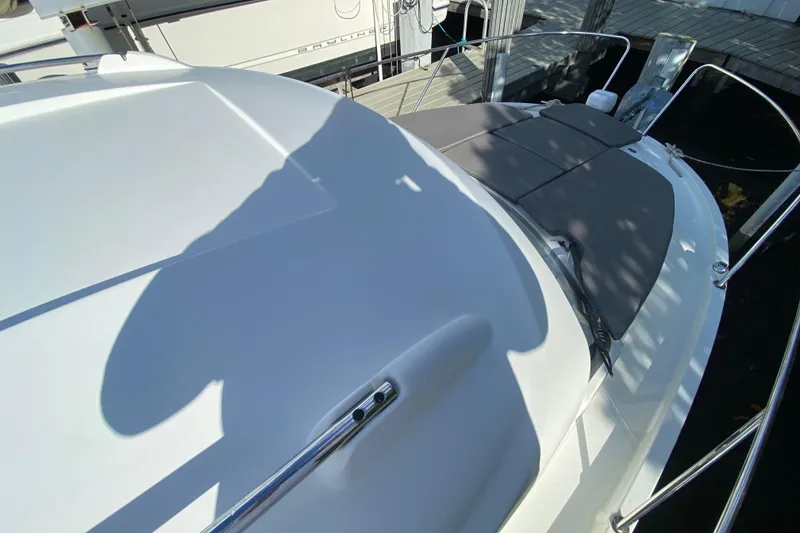 Slide: The Image of 2022 Beneteau Antares 8 boat deck with sunpad and railing, docked at marina. - 16