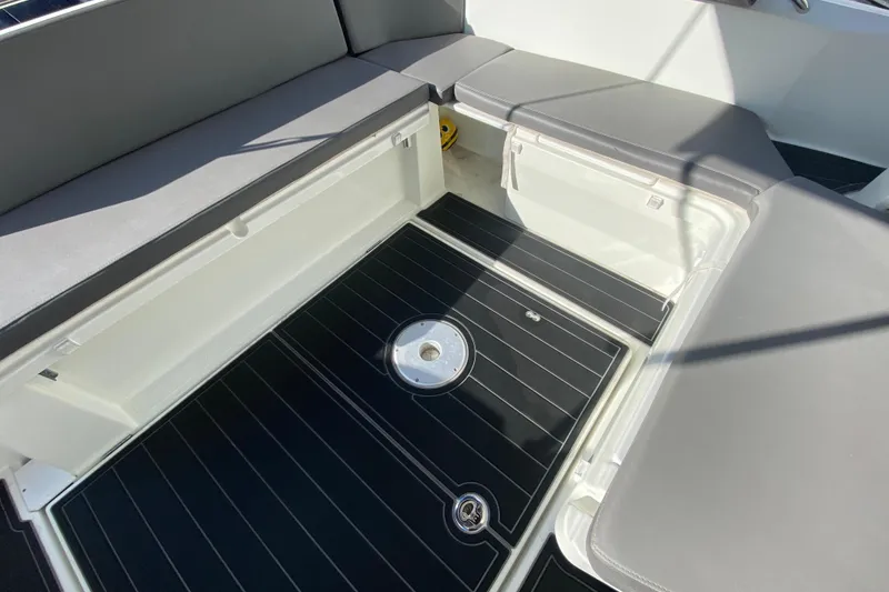 Slide: The Image of 2022 Beneteau Antares 8 boat interior with open storage compartment and cushioned seating. - 18