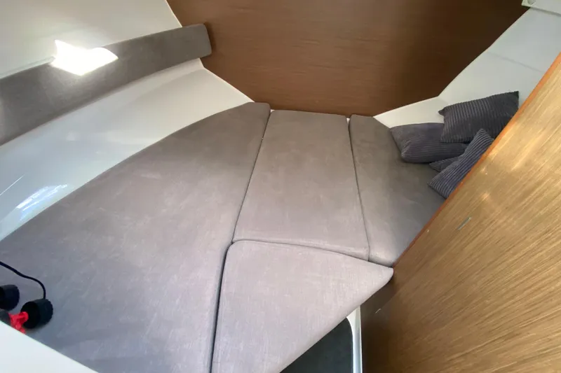 Slide: The Image of Cozy cabin interior of 2022 Beneteau Antares 8 with cushioned seating and pillows. - 32