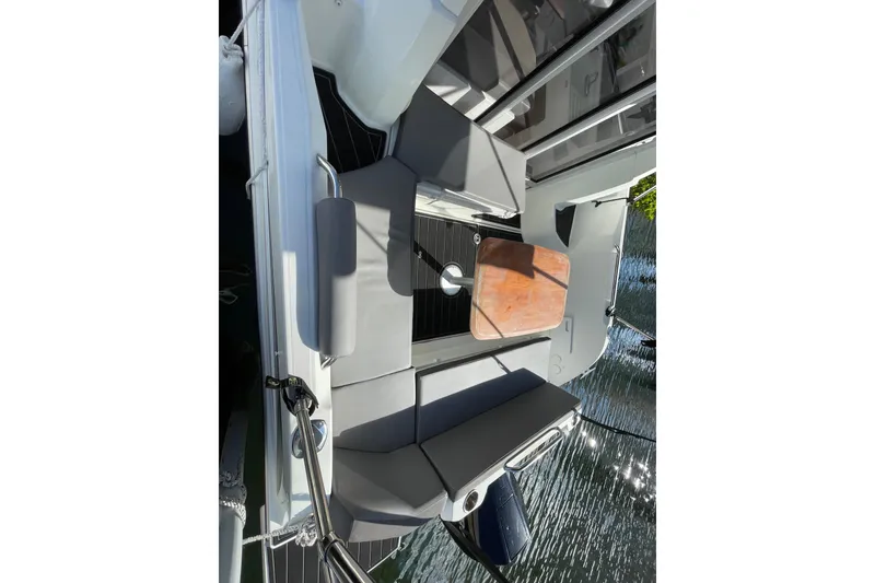 Slide: The Image of 2022 Beneteau Antares 8 boat interior with seating and wooden table. - 35
